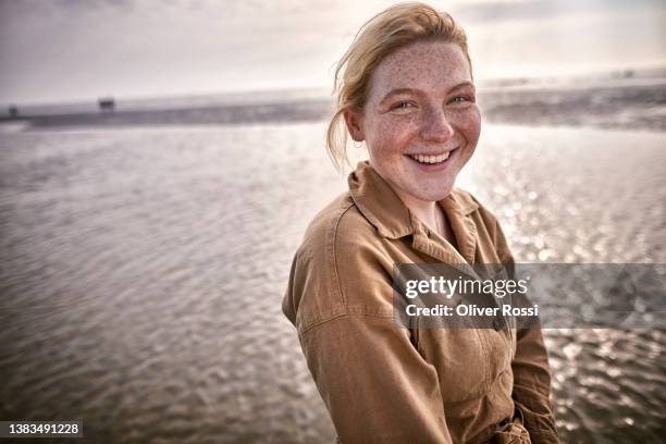 portrait of happy young woman on the beach - waterfront stock pictures, royalty-free photos & images