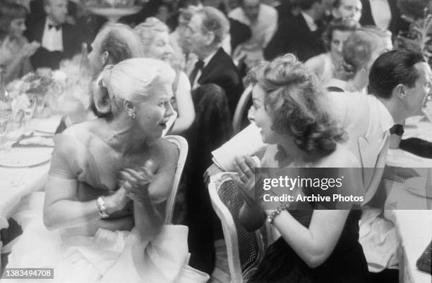 American actress and dancer Ginger Rogers and actress Susan Hayward chatting at the Cannes Film Festival in France, 1st May 1956.