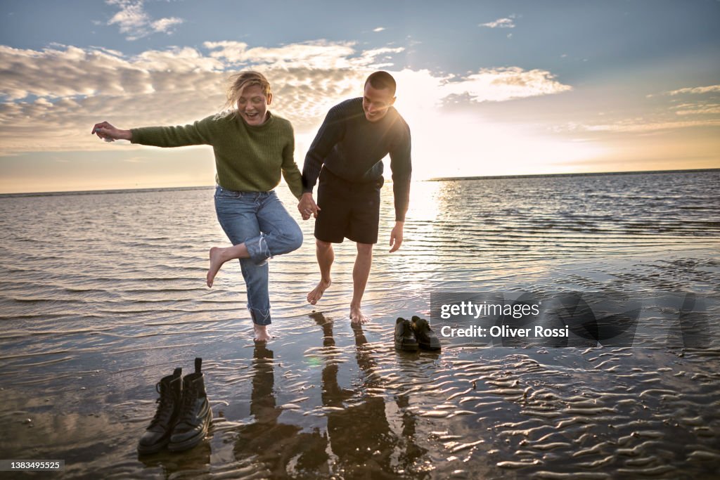 Carefree young couple by the sea at sunset