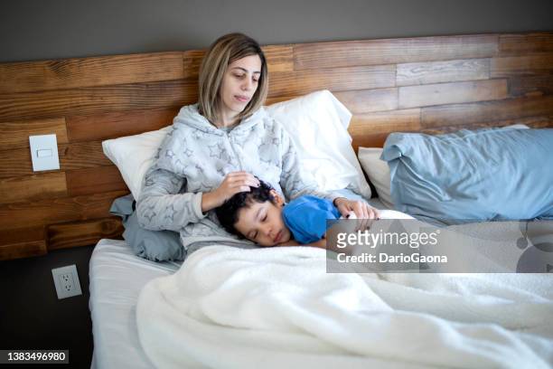 madre e hijo acostados en la cama - madre e hijo stockfoto's en -beelden