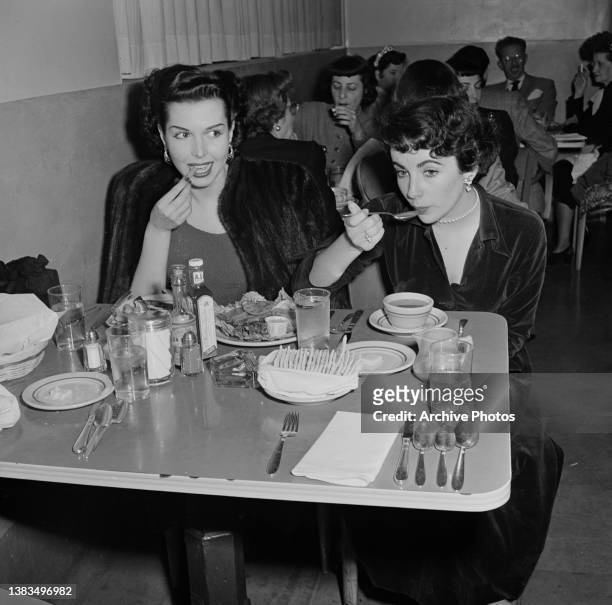 Actress Elizabeth Taylor eating with actress and dancer Ann Miller , USA, circa 1948.