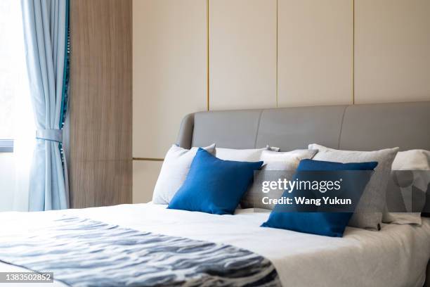 clean, bright and tidy bedroom with pillows on the bed - hotelroom stockfoto's en -beelden