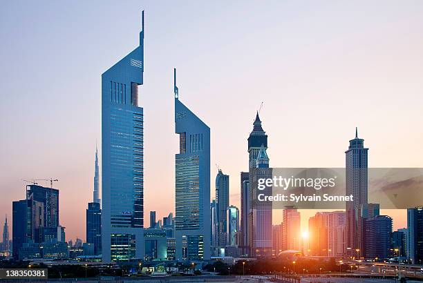 dubai, emirates towers and skyscrapers at sunset - emirates towers stockfoto's en -beelden