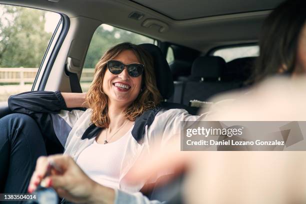 ethnic woman laughing in automobile - ethnic woman driving a car stock pictures, royalty-free photos & images