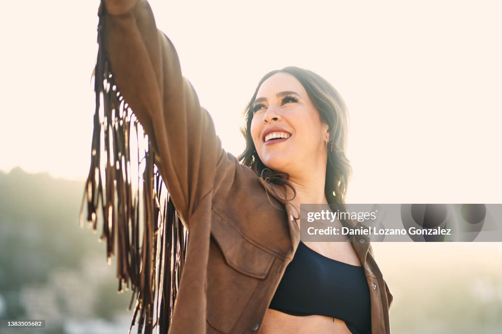 Content woman in fringe jacket in nature