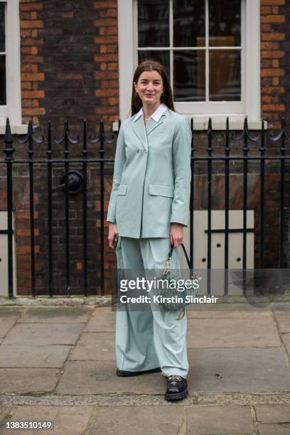Georgie Hyatt wears an Eudon Choi suit, Christian Dior saddle bag and Gucci shoes during London Fashion Week February 2022 on February 19, 2022 in...