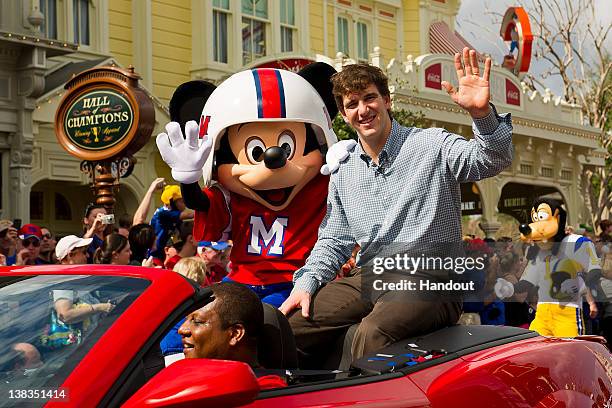 In this handout image provided by Disney Parks, Super Bowl XLVI MVP and New York Giants quarterback Eli Manning takes a celebratory ride with Mickey...