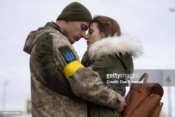 Vladimir Golyadynets says goodbye to his partner Olga Shmigal before boarding a train to Dnipro from the main train terminal on March 09, 2022 in...
