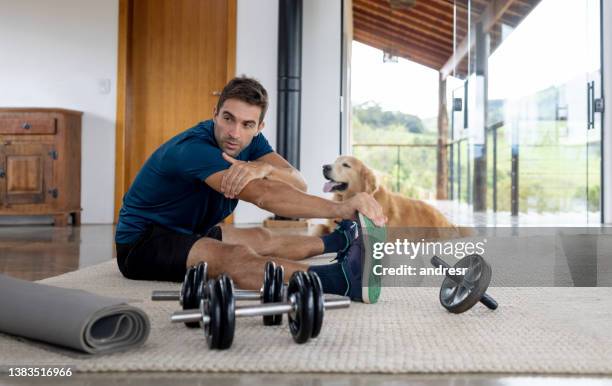 fit man stretching at home with the company of his dog - rug isolated stock pictures, royalty-free photos & images