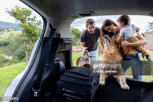 bonne famille à charger des sacs dans la voiture et à partir en road trip - dog in car photos et images de collection