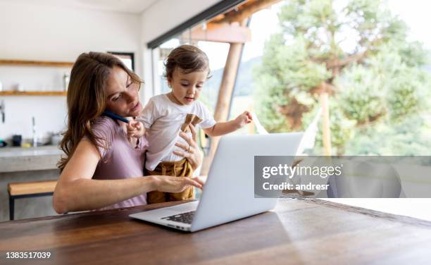 vielbeschäftigte mutter, die zu hause arbeitet, während sie sich um ihren sohn kümmert - stressed mum stock-fotos und bilder