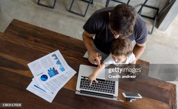 father working at home but baby interrupting his session - parental leave stockfoto's en -beelden