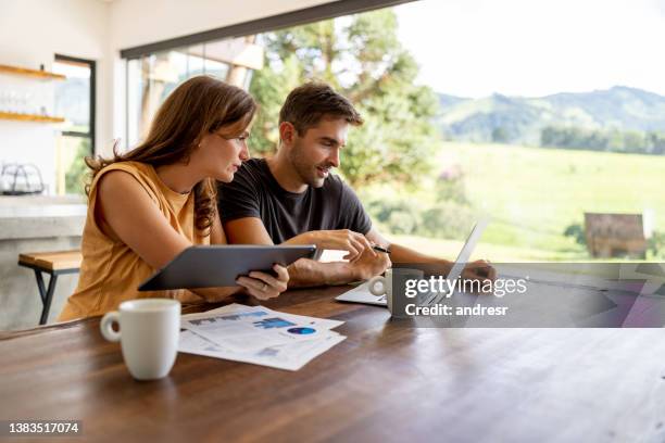 geschäftspartner, die zu hause arbeiten und dabei technologie nutzen - mietshaus stock-fotos und bilder
