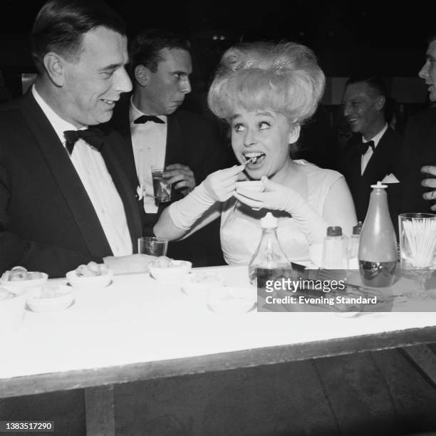 English actress Barbara Windsor eating whelks at the premiere of the film 'Sparrows Can't Sing' at the ABC Cinema on Mile End Road in London, UK,...