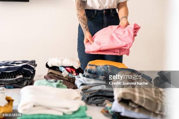 unrecognizable woman ordering the clothes from her closet in her room. - multi colored dress photos et images de collection