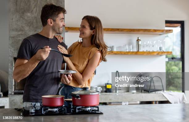 loving couple cooking dinner together - kitchen cooking stockfoto's en -beelden