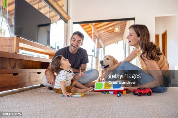 des parents heureux qui jouent à la maison avec leur bébé - bébé jeu photos et images de collection