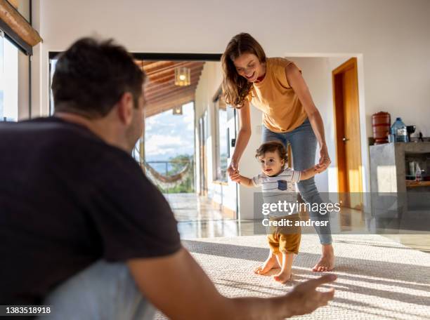 happy boy learning to walk and taking a few steps toward his father - mum dad and baby stock pictures, royalty-free photos & images