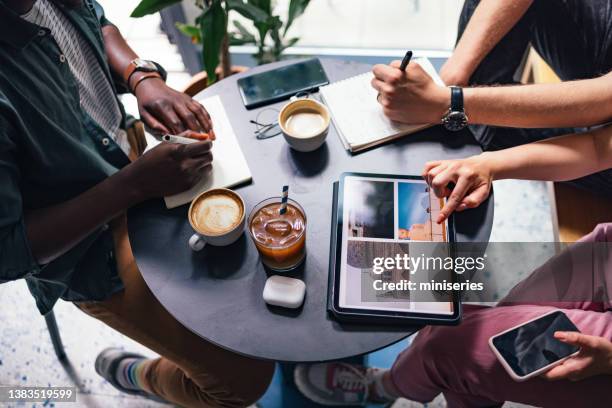 an anonymous group of people using digital tablet and notebooks for planing next trip together - man ipad holiday stockfoto's en -beelden