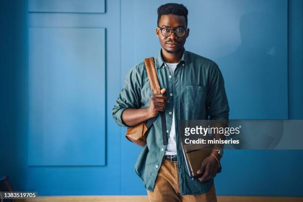 porträt eines gutaussehenden mannes, der vor einer blauen wand steht - school teacher blue stock-fotos und bilder