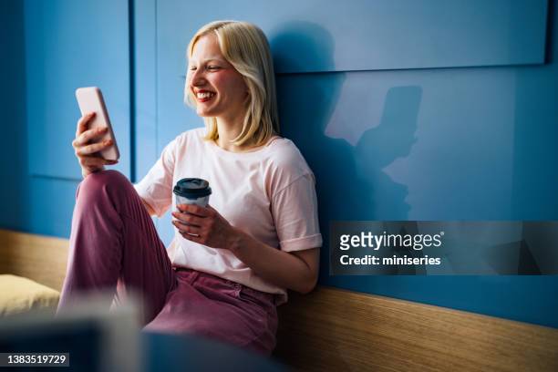 happy woman sitting in a cafe and looking at mobile phone - leisure work coffee happy stockfoto's en -beelden