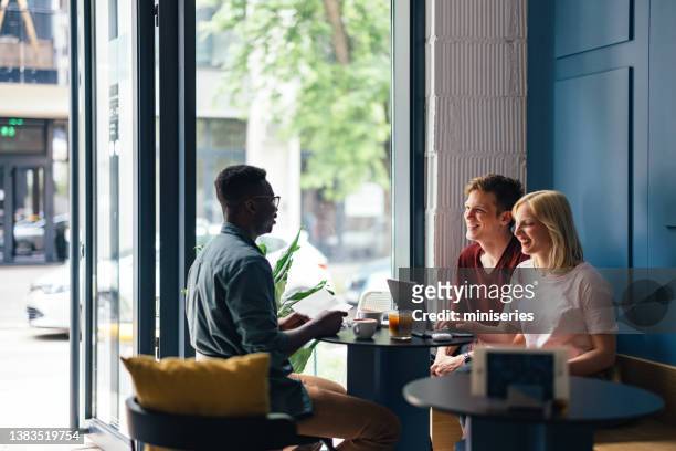 happy students having fun while studying together in a coffee shop - leisure work coffee happy stockfoto's en -beelden