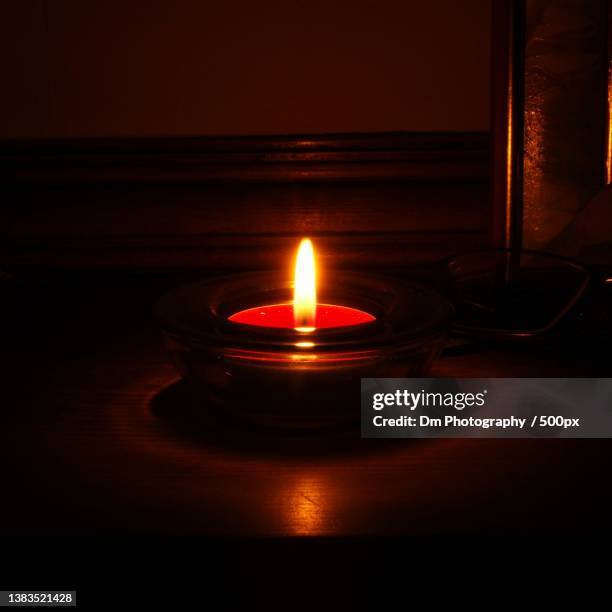 close-up of illuminated tea light candle on table - värmeljus bildbanksfoton och bilder