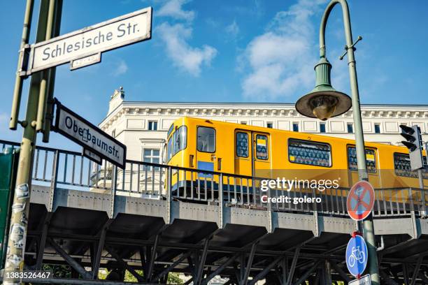 yellow metro train on elevated railway track in berlin kreuzberg - kreuzberg stock pictures, royalty-free photos & images