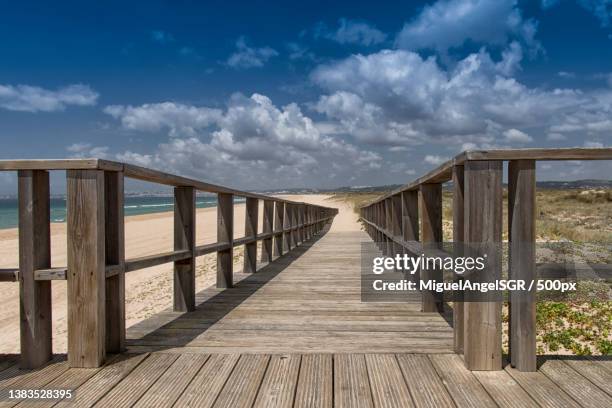 cambio de aires,empty wooden boardwalk leading towards sea against sky,distrito de faro,portugal - distrito de faro portugal 個照片及圖片檔