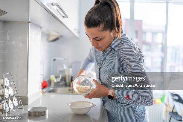 woman holding a jar of rice - rice production stockfoto's en -beelden