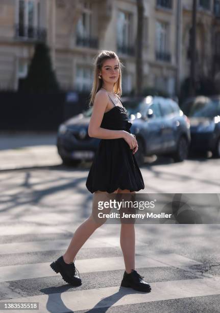 Millane Friesen seen wearing gold earrings, gold necklaces, a black mini dress, a black leather jacket and black derby loafers during Paris Fashion...