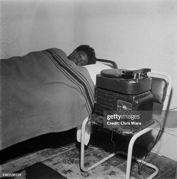 Letitia Asihene, a student from the Gold Coast, plays music to get to sleep with a radiogram at the International Students Club in Croydon, London,...