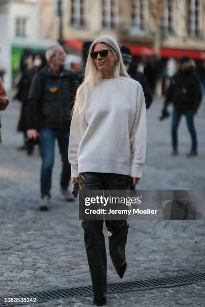 Sarah Harris wearing black shades, a white knit pullover, black leather pants and black heels outside Stella McCartney during Paris Fashion Week on...