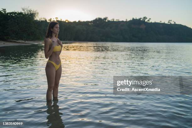 young woman goes for a morning swim, in calm water - ankle deep in water bildbanksfoton och bilder