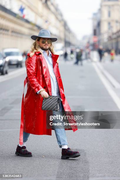 Influencer Justus Toussis wearing a red patent leather double breasted trench coat by Burberry, a light blue capri rancher hat by Lack of Color, a...