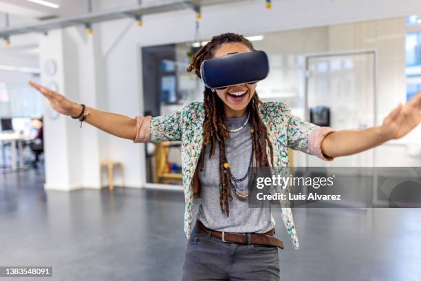 excited woman wearing virtual reality testing new metaverse in office - motion study stock pictures, royalty-free photos & images