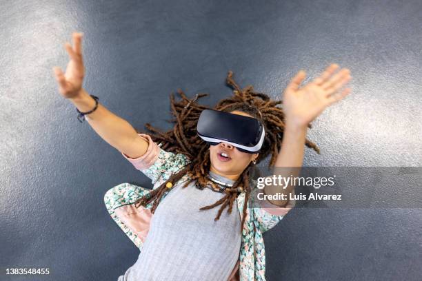 woman testing new metaverse with virtual reality glasses in office - top prospects game stock-fotos und bilder