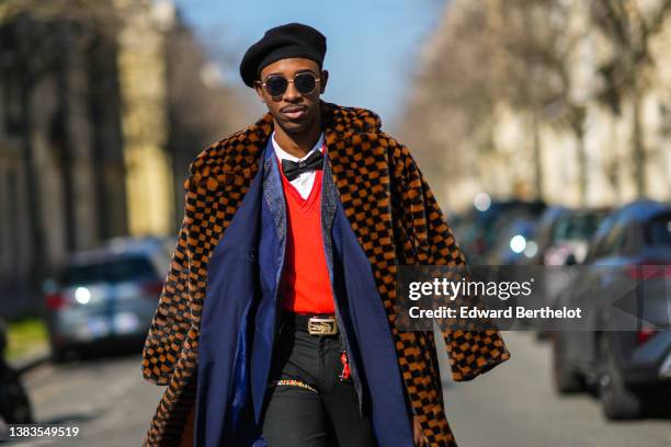 Guest wears a black felt / wool beret, black sunglasses, a white shirt, a black silk bow tie, a red V-neck wool pullover, a navy blue silk blazer...