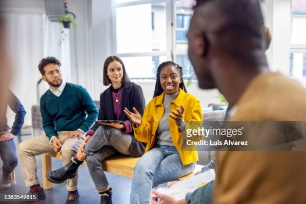 woman sharing her view during team building session at startup office - mature business woman digital tablet corporate professional stockfoto's en -beelden