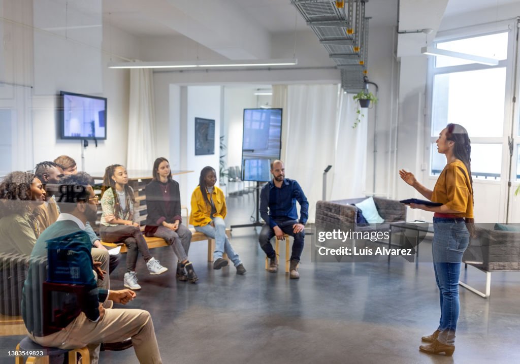 Young asian businesswoman speaking to her coworkers in meeting