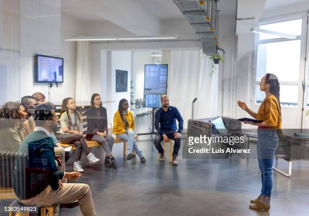 young asian businesswoman speaking to her coworkers in meeting - briefing imagens e fotografias de stock