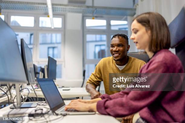 young man and woman sitting at desk working on laptop - code 41 bildbanksfoton och bilder