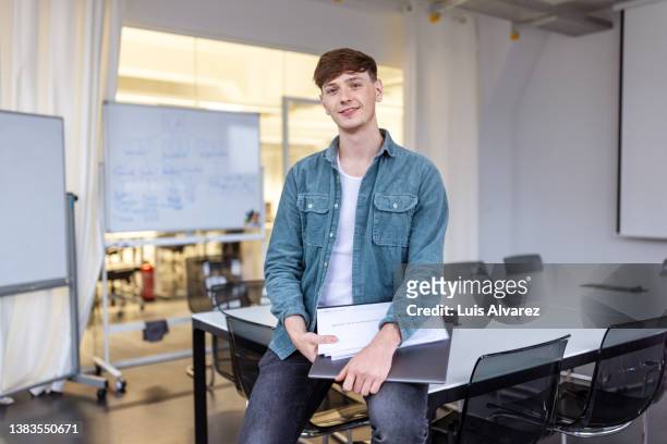 portrait of a young man standing in startup office - creative director stock pictures, royalty-free photos & images