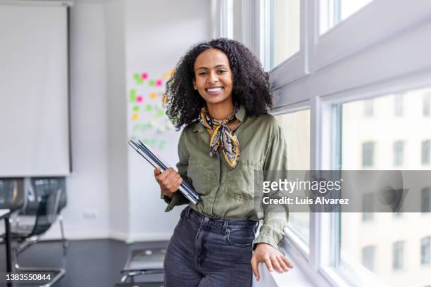 smiling portrait of a beautiful woman standing in office - casual chic foto e immagini stock