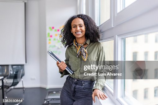 Smiling portrait of a beautiful woman standing in office Smiling portrait of a beautiful woman standing in office