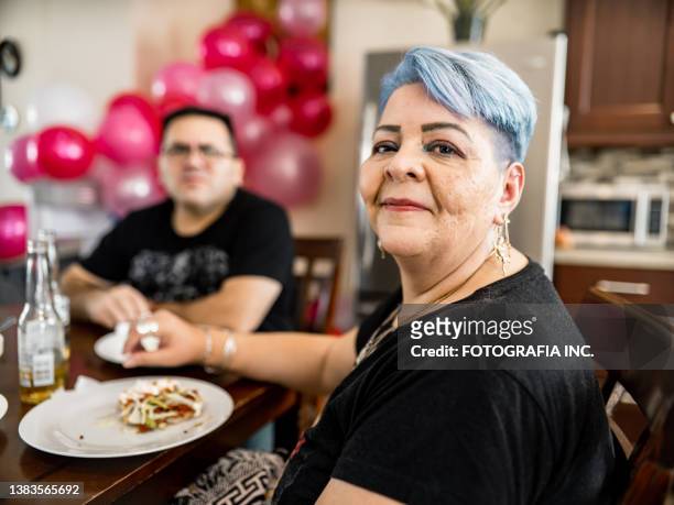 mature mexican woman at the party table - older woman colored hair stock pictures, royalty-free photos & images