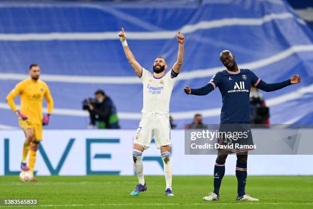 Karim Benzema of Real Madrid celebrates after scoring their team's second goal as Danilo Pereira of Paris Saint-Germain looks dejected during the...