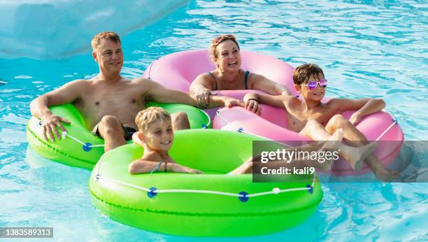 family with two boys float on lazy river at water park - lazy river stock pictures, royalty-free photos & images