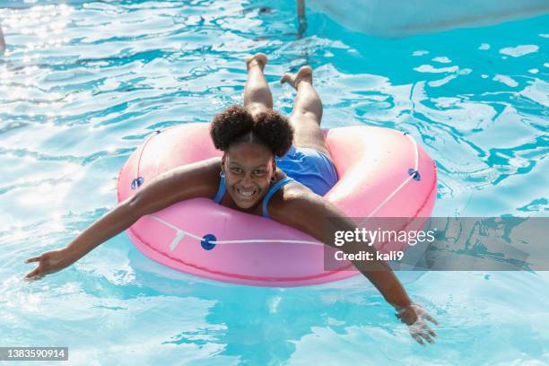 african-american girl floats on lazy river at water park - preteen girl swimsuit stock pictures, royalty-free photos & images