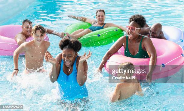 multirassische freunde und familie beim planschen auf dem lazy river - girls and boys playing in waterpark stock-fotos und bilder